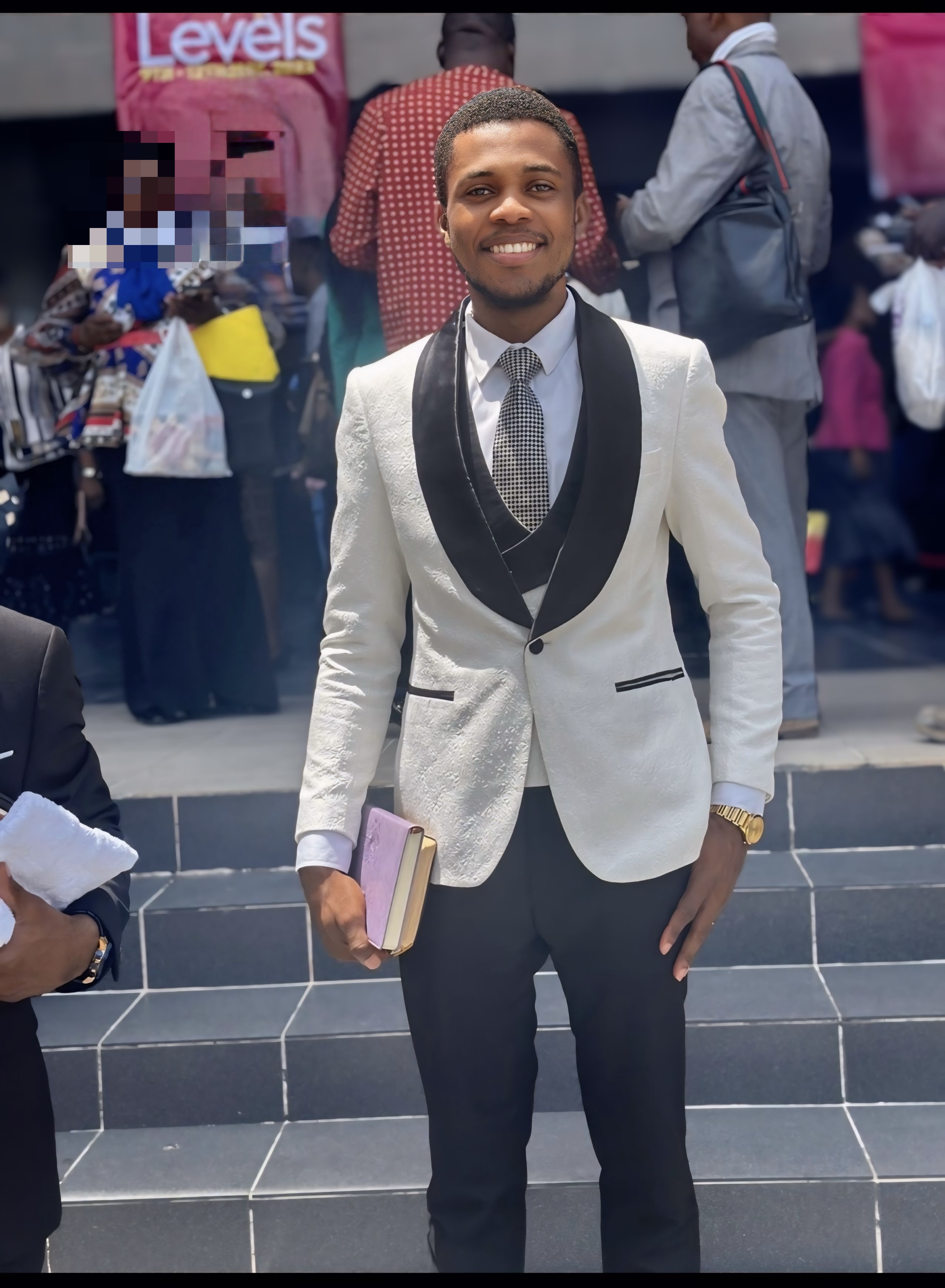 Pastor Samuel A. Ewool in a white and black suit