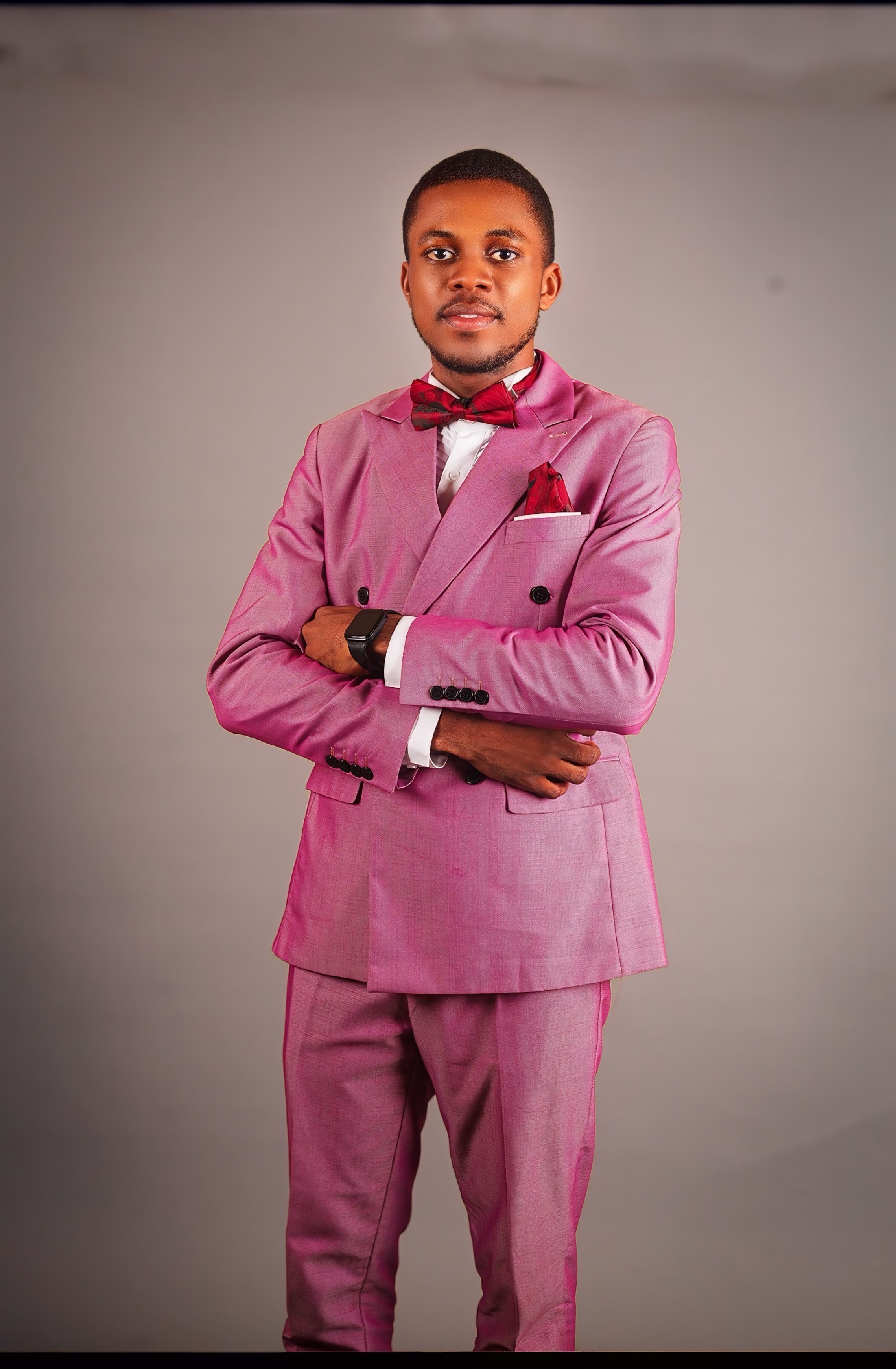 Pastor Samuel A. Ewool formal pink suit portrait with folded arms