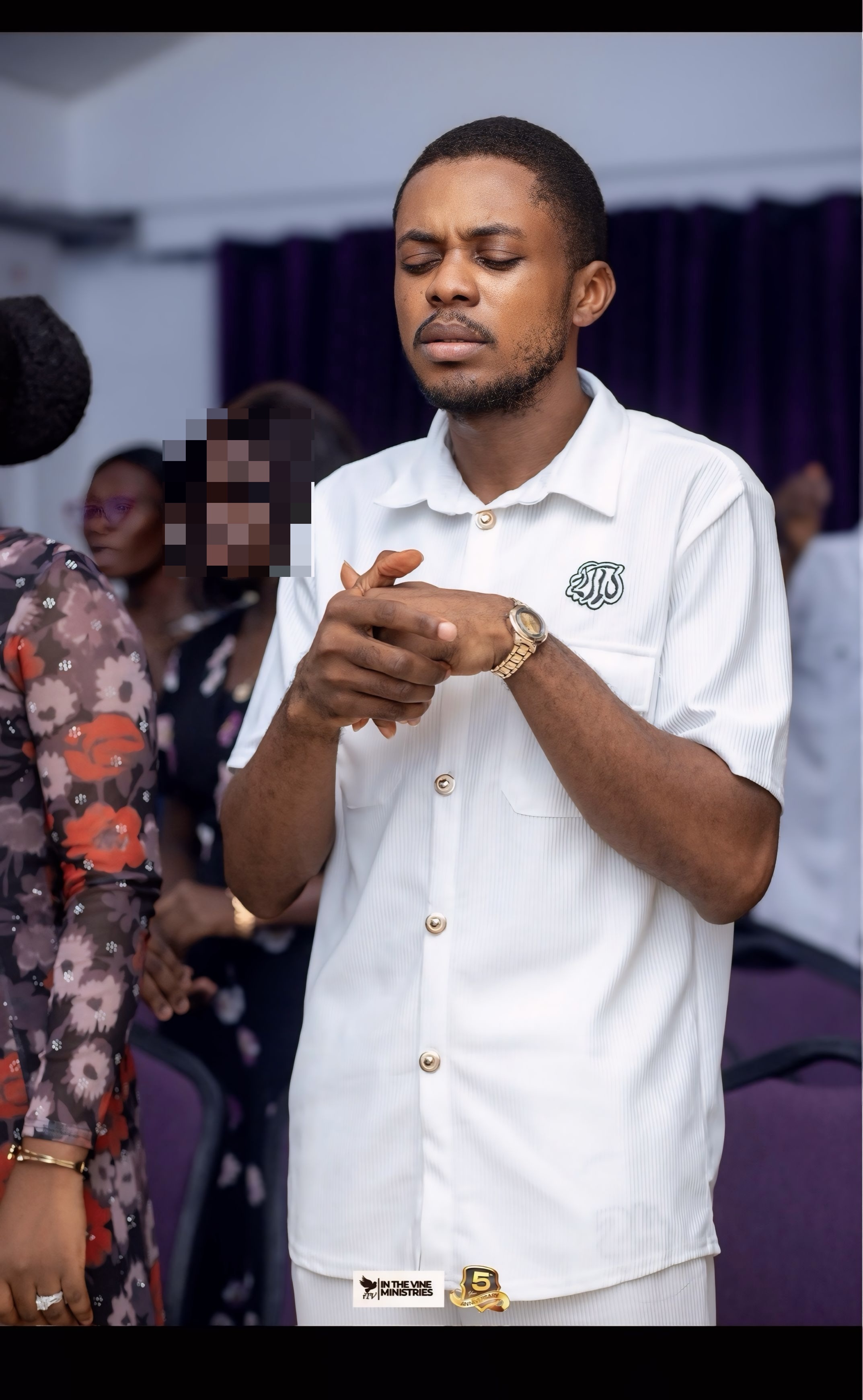 Pastor Samuel A. Ewool praying during a conference