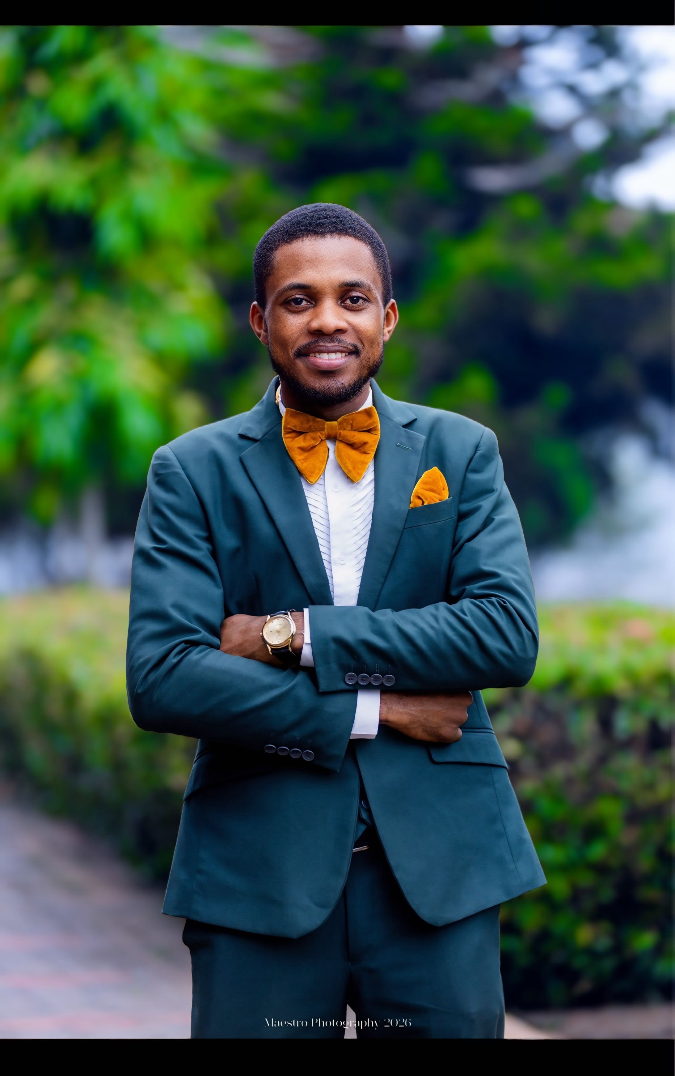 Pastor Samuel A. Ewool in a green suit seated outdoors